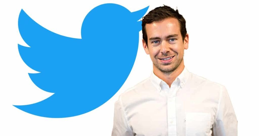 Jack Dorsey, co-founder of Twitter, standing next to the Twitter logo