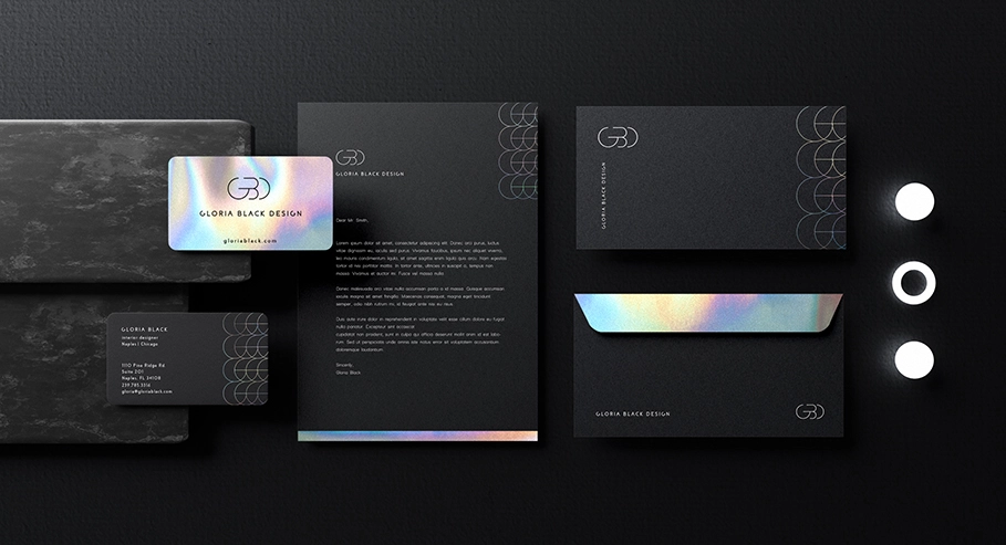 Collection of business stationery items including business cards, letterheads, and envelopes with a modern logo featuring intertwined ‘G’ and ‘B’ letters, laid out on a dark surface.